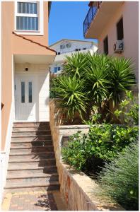 a stairway leading to a house with palm trees at Apartments Rupe in Primošten