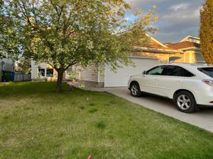 a white car parked in the driveway of a house at citadle hill house! in Calgary +8 photos