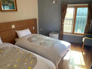 Postel nebo postele na pokoji v ubytování Izu-no-umi Hotel