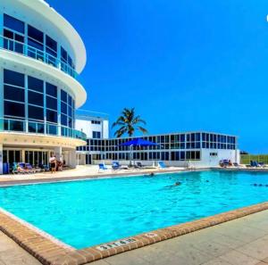 a swimming pool in front of a building at Luxury - Ocean front - 3 Bedroom 2 Bathroom - Penthouse in Miami Beach