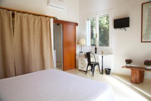 a bedroom with a bed and a desk and a window at Luna&Limoni Country in Muravera