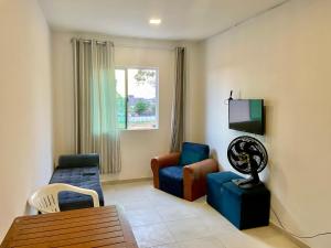 a living room with a couch and chairs and a television at Apto1 - Próximo ao Shopping Metrópole in Ananindeua