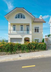 a white house on the side of a street at The Hill An Sơn DIC in Xuan An