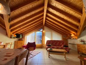 a living room with wooden ceilings and a red couch at Grand T3 lumineux avec balcon, parking & casier skis en centre-ville de Samoëns - FR-1-624-22 in Samoëns