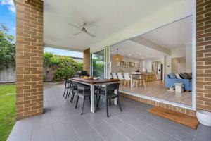a patio with a table and chairs and a living room at Tea Tree Retreat - 5 Bedrooms, sleeps 13 in Inverloch