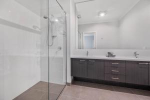 a bathroom with a glass shower and a sink at Tea Tree Retreat - 5 Bedrooms, sleeps 13 in Inverloch +25 photos