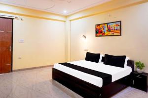 IndirapuramにあるHotel O Rudraのベッドと壁に絵が飾られた寝室