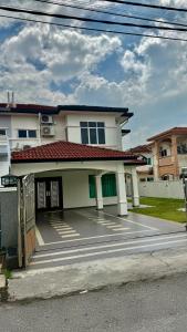 a white house with a driveway in front of it at no7 HOMESTAY in Tanjung Karang
