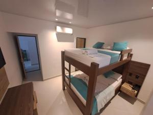 a bedroom with two bunk beds and a mirror at Hotel Luna Verde in Doradal