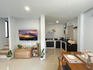 a kitchen and living room with a table and a television at Borbaimai home in Chiang Rai