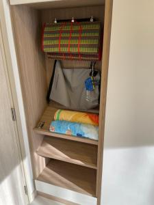 un petit placard avec des étagères en bois et une valise dans l'établissement Studio Apartment, Bang Tao Phuket, à Laguna Phuket