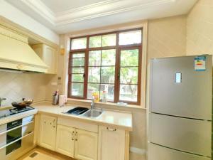 a kitchen with a sink and a refrigerator at Sanya beach sweet house in Luoyushangcun