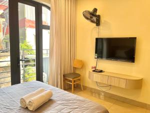 a bedroom with a bed and a flat screen tv at Hanoi’s Lane Homestay in Hanoi