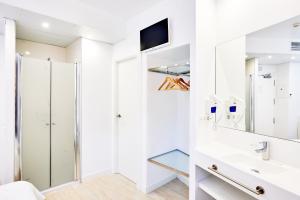 a white bathroom with a shower and a sink at AMC Granada in Granada