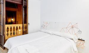 a bedroom with a white bed with white sheets at AMC Granada in Granada