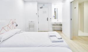 ein weißes Schlafzimmer mit einem großen Bett und einem Waschbecken in der Unterkunft AMC Granada in Granada