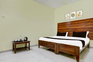 a bedroom with a large bed with a wooden headboard at SPOT ON SRI KARTHIK GRAND INN in Warangal +21 photos