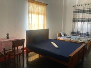 a bedroom with a bed and a table and a table and chairs at Jesuit Residence in Galle