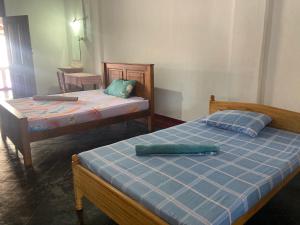 two beds sitting in a room with at Jesuit Residence in Galle