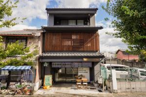 京都市にあるTHE ROOT2 HOTELの木造の外観の建物で、正面に椅子が備わります。
