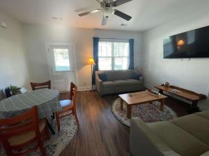 a living room with a couch and a table at The Capital Cottage New Home Near USC & Bases in Columbia