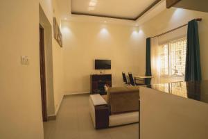 a living room with a couch and a television at Aparthotel Madeleine in Antananarivo