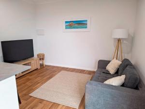 a living room with a couch and a flat screen tv at The Salthouse in Quindalup