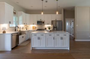 une grande cuisine blanche avec des armoires et des appareils blancs dans l'établissement Your Own Crashpad, à Jacksonville