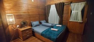 a small bedroom with a blue bed and a window at Mentawai ASA Homestay in Siberimanua