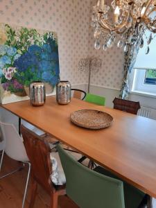 a dining room table with chairs and a painting at Das Landhaus Oberstdorf in Oberstdorf
