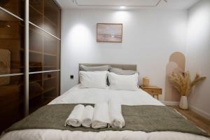 Un dormitorio con una cama con toallas. en Cozy & Modern Apartament in the Heart of the City, en Craiova