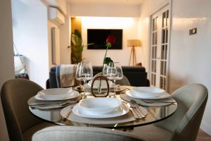una mesa de comedor con platos y copas de vino en Cozy & Modern Apartament in the Heart of the City, en Craiova