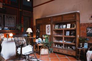 a room with a wooden book shelf and a chair at 序室 Narrative in Jinhu