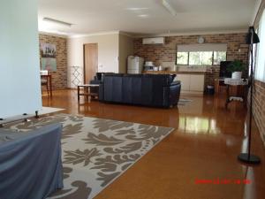 a living room with a couch and a kitchen at Emerald Tropical Palms B & B in Emerald Beach