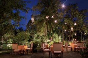 a restaurant with tables and chairs at night at Lynnaya Urban River Resort in Siem Reap