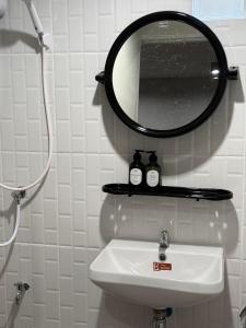a bathroom with a sink and a mirror on the wall at theriverhouse in Ban Muang Nga