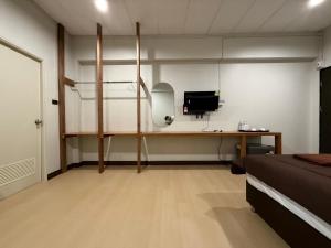 a bedroom with a bed and a desk with a computer at theriverhouse in Ban Muang Nga