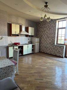 a kitchen with white cabinets and a table in a room at ALYAM Comfortable apartment In Baku in Baku