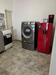 a washing machine next to a red refrigerator at Departamento independiente en Juárez in Ciudad Juárez