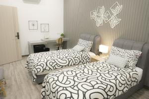 a bedroom with two beds and a bed and a fireplace at Suites Only KKB in Kuala Kubu Bharu