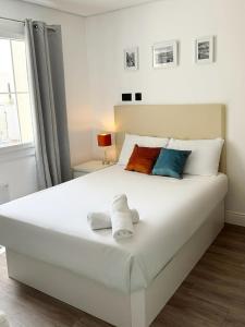 a bedroom with a large white bed with towels on it at Grand Central House - Central Penthouse Double Room Ensuite - GibraltarStay Apartments in Gibraltar