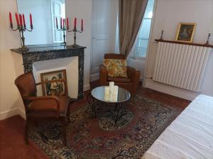 a living room with a fireplace and a table and chairs at La maison au bord de l'eau in Graçay