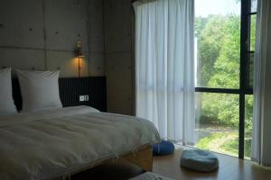 Postel nebo postele na pokoji v ubytování ThreeLogy Cafe&Craft