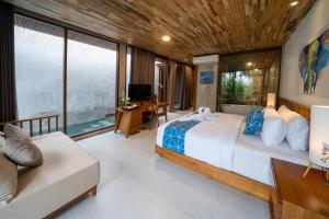 a bedroom with a large bed and a couch at Langit Pitu Villas in Ketewel