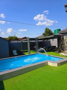 a swimming pool in a yard with a fountain at The greenary guest house and restaurant in Thohoyandou