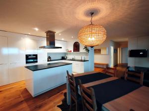 a kitchen and dining room with a table and a chandelier at Luxury Escape - Titlis Panorama in Engelberg