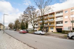 eine Straße mit am Straßenrand geparkten Autos in der Unterkunft Homaris Apartments München Laim in München