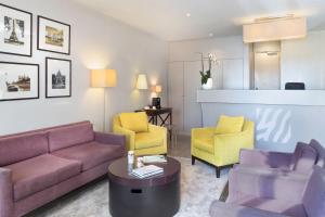 a living room with purple couches and yellow chairs at Best Western Rives de Paris La Defense in Courbevoie