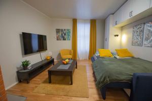 a bedroom with a bed and a tv and a table at KarlovaIdyll 2 - Cozy Apartment in a Quiet Area with FREE Parking in Tartu