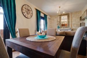 een eetkamer met een tafel en een klok aan de muur bij Luxury 2br apartment 50m from beach in Pefkochori